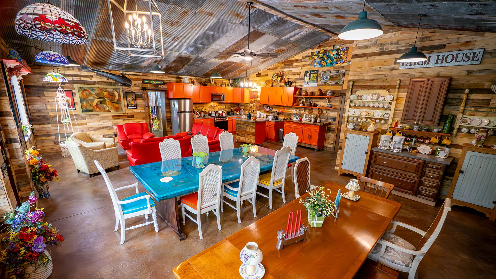 A cozy, rustic kitchen and dining area featuring colorful furniture, wooden walls, and decorative items.